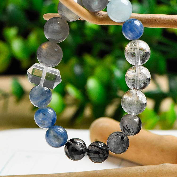 Green Phantom Quartz symbolizes growth rising through the darkness, Aquamarine brings the calm of a night sky in motion, Clear Quartz adds radiant clarity, Rutilated Quartz mirrors the golden streaks of starlight, and Moonstone embodies lunar glow and intuitive flow.
